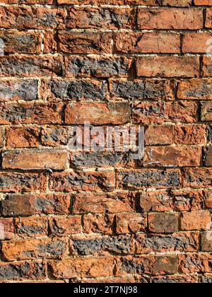 Alte rote Ziegelwand mit Frostschäden/Witterungseinflüssen, die zu Abplatzungen/Bersten/Zerbröckeln/Rissen an Ziegelflächen führen, England, Großbritannien Stockfoto