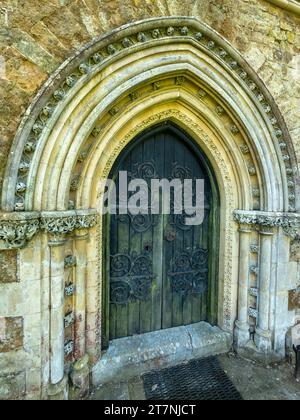 Alte, kunstvoll verzierte Kirchentür mit gotischen Bögen und mit Fleuron dekorierten Scharnieren St James Church, Little Dalby, Leicestershire, England, Großbritannien Stockfoto