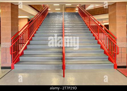 Rutschfeste Bodenstufen und Sicherheitsgeländer auf den Stufen einer Grundschultreppe. Stockfoto