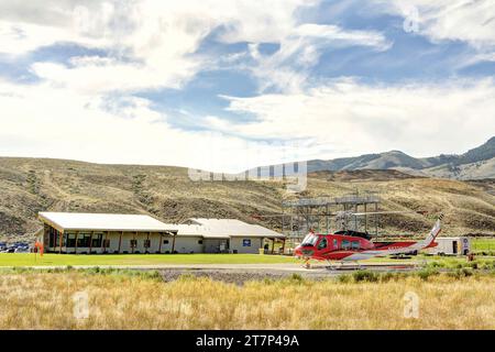 Ein Bereitschaftshubschrauber im Lachsflugstützgebäude in Salmon, Idaho, mit einem Stahlträgertrampel-Trainingsturm, in dem Feuerwehrleute trainieren, um zu unterstützen Stockfoto