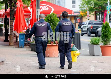 Zwei Polizisten aus Newark, die eine Straße in der Nachbarschaft Ironbound, Newark, New Jersey, entlang laufen. Stockfoto