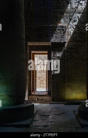 Licht strömt in das dunkle Innere des antiken Tempels von Edfu mit Hieroglyphen an den Wänden Stockfoto