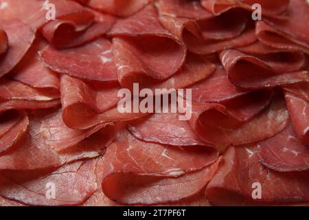 Scheiben leckerer Bresaola als Hintergrund, Nahaufnahme Stockfoto