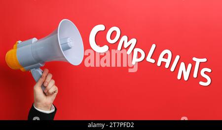 Mann mit Megaphon auf rotem Hintergrund, Nahaufnahme. Wortbeschwerden, die vom Gerät ausgegeben werden. Bannerdesign Stockfoto