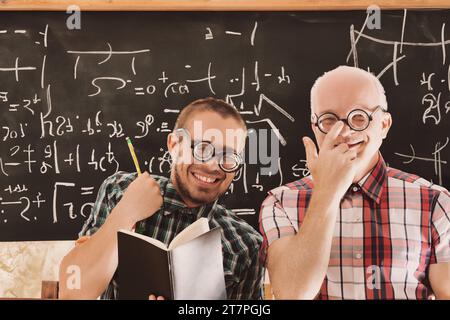 Freudige Mathematiker teilen einen humorvollen Moment in einem Klassenzimmer Stockfoto