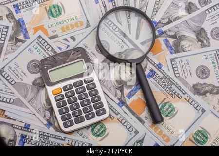 Lupe wird über die Banknote Bündel von US-Dollar gehalten. Stockfoto
