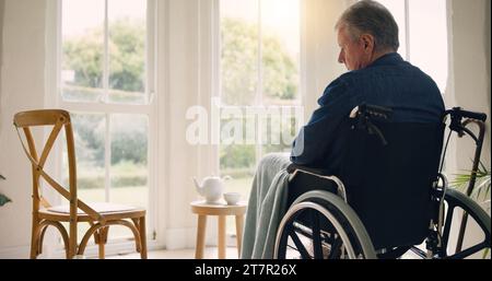 Rollstuhl, Seniorenmann oder Denken an Gedächtnis durch Fenster im Pflegeheim oder Ruhestand mit Depression. Nostalgie, traurige Geschichte oder einsame reife Person Stockfoto