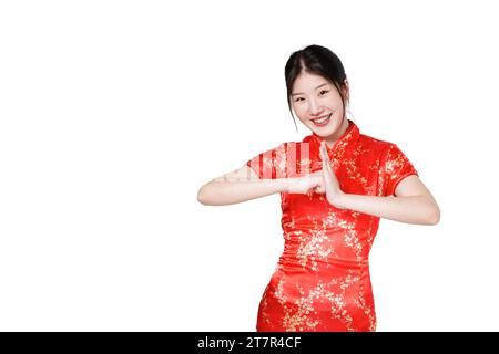 Glückliches chinesisches Neujahr. Asiatische Frau trägt traditionelles Cheongsam Qipao Kleid mit Glückwunschgeste isoliert auf weißem Hintergrund. Stockfoto