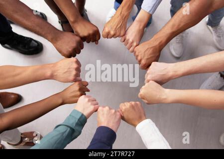 Multi-Ethnic-Team unterstützt Einheit mit Racial Fist Huddle Stockfoto