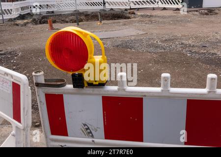 Nahaufnahme einer roten Warnleuchte mit Straßensperren auf einer Baustelle Stockfoto
