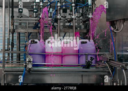 Automatische Abfüllmaschine wird in modernen Getränkefabriken in PET-Plastikflaschen gefüllt. Stockfoto