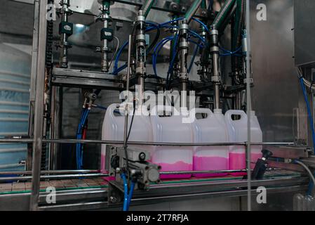 Automatische Abfüllmaschine wird in modernen Getränkefabriken in PET-Plastikflaschen gefüllt. Stockfoto