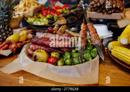 Weihnachtliches Street Food Festival auf Messe im Stadtzentrum, Winterferien. BBQ Street Food zum Verkauf, leckere Würstchen auf dem Holiday Street Market in europa Stockfoto