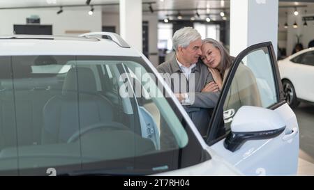 Ein älteres kaukasisches Paar wählt ein neues Auto in einem Autohändler. Stockfoto