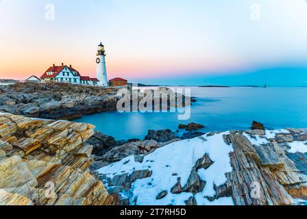 Ein malerischer Blick auf einen Leuchtturm an der Küste, bedeckt mit Schnee bei Sonnenuntergang in Portland Stockfoto