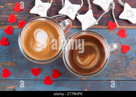 Blick von oben Tassen Cappuccino auf alter Planke und rotem Filzherz Stockfoto