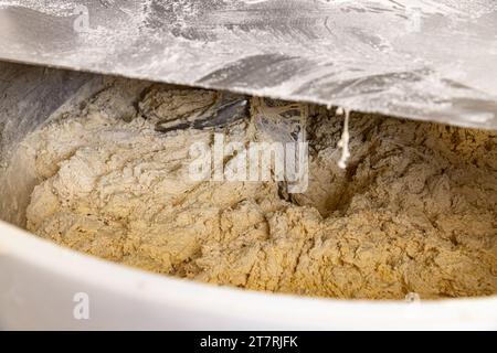 Teig für Brot in einem Kneter in einer Bäckerei machen. Industriemischer zum Kneten von Teig. Stockfoto