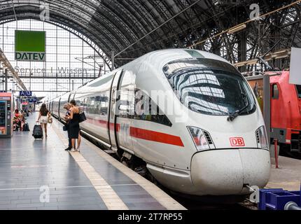 Ein Inspektor überprüft das E-Ticket einer jungen Frau vor einem ICE-Hochgeschwindigkeitszug von der Deutschen Bahn im Frankfurter Hauptbahnhof. Stockfoto