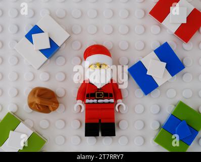 Tambow, Russische Föderation - 14. November 2023 Eine Lego Santa Claus Minifigur mit Tasche und Geschenkboxen um ihn herum auf weißem Hintergrund Stockfoto