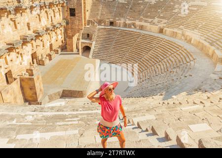 Touristen-Mädchen, die das römische Theater Aspendos in der Türkei besucht, hat Sitzplätze für 7000 Zuschauer, außergewöhnliche Akustik und sogar ein Flüstern von der Bühne Stockfoto