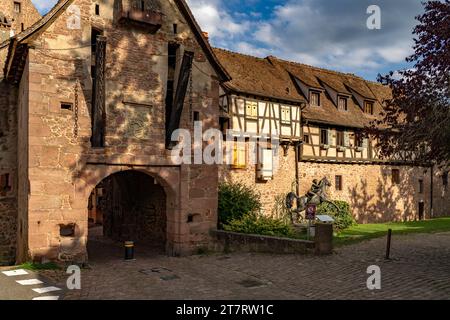 Das Obertor La Porte Haute und Fachwerkhäuser der Stadtmauer von Riquewihr, Elsass, Frankreich | befestigtes Stadttor La Porte Haute und Halbholz Stockfoto