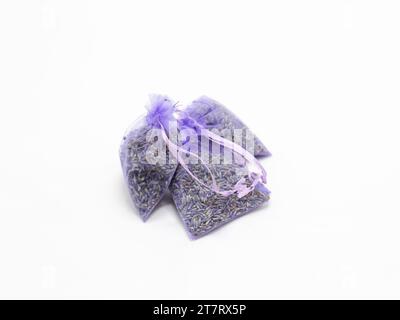 Zwei kleine violette Beutel, gefüllt mit getrocknetem Lavendel auf weißem Hintergrund. Stockfoto