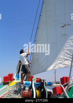 Seixal, Portugal. 20. Juni 2023: Segler heben oder setzen die Hauptsegel auf dem Segelboot Amoroso, einem historischen, typischen oder traditionellen Varino Typ T Stockfoto