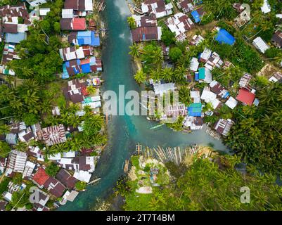 Häuser und Fischerboote entlang der Bogac Cold Spring in Surigao del Sur. Philippinen. Stockfoto