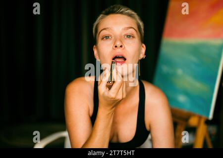 Eine junge Frau, die Lippenstift auf die Lippen aufträgt Stockfoto