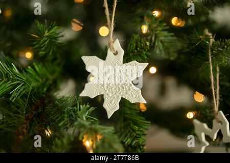 Weiße Schneeflocken hängen an einem weihnachtsbaumzweig Stockfoto