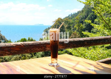 Kaffee mit Milch, Zucker und Eis in einem Café mit Blick auf das Meer. Das Konzept der Entspannung, des Urlaubs, der Reise. Stockfoto