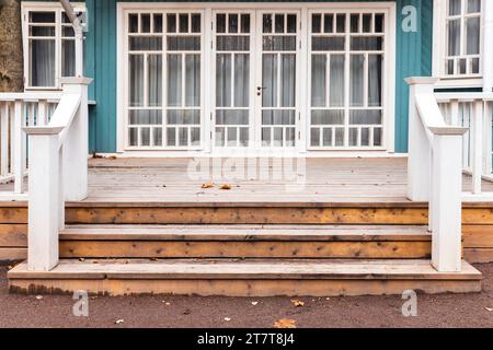 Hinterhof-Hintergrundfoto mit einer leeren Holzterrasse und Treppen eines alten Landhauses, Vorderansicht Stockfoto