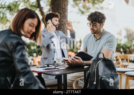 Geschäftsleute diskutieren in einer Coffee Bar in der Stadt über erfolgreiche Geschäftsausweitungen, Vertriebsstrategien und Budgetmanagement. Stockfoto