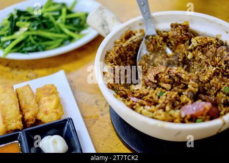 Claypot-Hühnerreis, hausgemachte Meeresfrüchte-Bohnenquark mit süßem Chili und Mayo-Dipping-Sauce, gebratene Süßkartoffelblätter im Heun Kee, Pudu Stockfoto