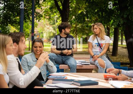 Eine Gruppe verschiedener Universitätsstudenten, die sich mit akademischen Debatten und der Zusammenarbeit im Campus Yard beschäftigen Stockfoto