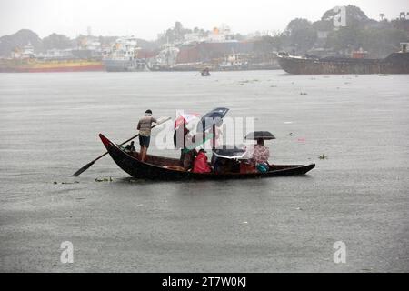 Bangladeschische Passagiere überqueren den Buriganga River während des starken Regens, da der Zyklon Midili das Küstengebiet in Dhaka, Bangladesch, am 17. November 2023 beeinflusst. Nach Angaben des Meteorologischen Departements Bangladesch (BMD) und der Bangladesch Inland Water Transport Authority (BIWTA) wird sich der Wirbelsturm Midili voraussichtlich weiter nordnordöstlich bewegen und die Küste bis zum 17. November überqueren, abends und alle Arten von Flussschiffen wurden aufgrund des Zyklonsturms den Betrieb ausgesetzt. aufgrund des Klimawandels treten in Bangladesch häufig Wirbelstürme und Überschwemmungen auf. Foto: Habibur Rahman/ABACAPRESS.COM Stockfoto