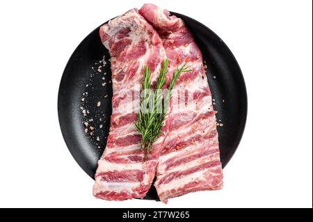Rohe Schweinerippchen, gewürzt mit Gewürzen in einer Pfanne. Isolieren, weißer Hintergrund Stockfoto