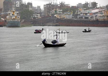 Dhaka, Wari, Bangladesch. November 2023. Bangladeschische Passagiere überqueren den Buriganga River während des starken Regens, da der Zyklon Midili das Küstengebiet in Dhaka, Bangladesch, am 17. November 2023 beeinflusst. Nach Angaben des Meteorologischen Departements Bangladesch (BMD) und der Bangladesch Inland Water Transport Authority (BIWTA) wird sich der Wirbelsturm Midili voraussichtlich weiter nordnordöstlich bewegen und die Küste bis 17. November Abend überqueren und alle Arten von Flussschiffen wurden aufgrund des Zyklonsturms ausgesetzt. aufgrund des Klimawandels treten in Bangladesch häufig Wirbelstürme und Überschwemmungen auf. (Guthaben Stockfoto