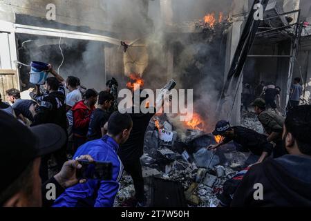 Rafah, Palästinensische Gebiete. November 2023. Palästinenser versuchen, ein Feuer nach einem israelischen Luftangriff auf ein Haus im Flüchtlingslager Shaboura zu löschen. Abed Rahim Khatib/dpa/Alamy Live News Stockfoto