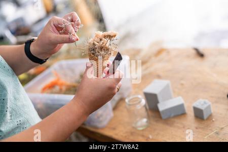 Florist, der einen Blumenstrauß mit getrockneten Blumen in einer Eiskegel bastelt Stockfoto