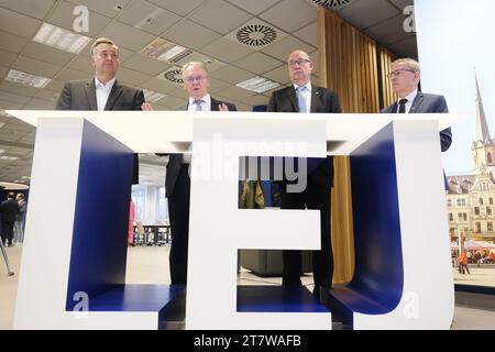 Schkeuditz, Deutschland. November 2023. Markus Otto (l-r), Geschäftsführer der DHL European Air Transport Leipzig GmbH, reiner Haseloff (CDU), Ministerpräsident von Sachsen-Anhalt, Hartmut Handschak (Nichtpartei), Landrat Saale, und Torsten Ringling, Bürgermeister der Stadt Schkopau, stehen an einem Schreibtisch in Form des Flughafencodes des Flughafens Leipzig/Halle. Haseloff traf sich, um das Thema Fluglärm in Sachsen-Anhalt zu erörtern. Quelle: Sebastian Willnow/dpa/Alamy Live News Stockfoto