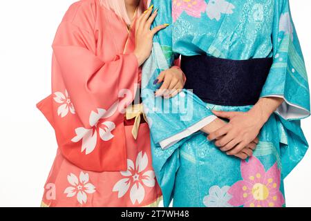 Zugeschnittene Ansicht eines Anime-Paares in hellen und eleganten Kimonos auf weißer, japanischer Cosplay-Subkultur Stockfoto