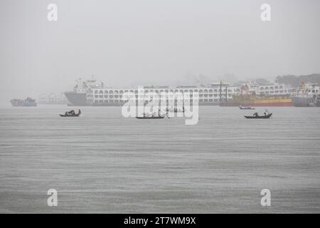 Wirbelsturm Midhili trifft Küstengebiet in Bangladesch Bangladesch Passagiere überqueren den Buriganga River während des starken Regens, während der Zyklon Midili die Küstengebiete in Dhaka, Bangladesch, am 17. November 2023. Nach Angaben des Meteorologischen Departements von Bangladesch BMD und der Bangladesch Inland Water Transport Authority BIWTA wird sich der Wirbelsturm Midili wahrscheinlich weiter nordnordöstlich bewegen und die Küste bis 17. November Abend überqueren und alle Arten von Flussschiffen wurden aufgrund des Zyklonsturms ausgesetzt. aufgrund des Klimawandels treten Zyklone und Überschwemmungen in Bangladesch häufiger auf. Stockfoto