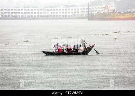 Wirbelsturm Midhili trifft Küstengebiet in Bangladesch Bangladesch Passagiere überqueren den Buriganga River während des starken Regens, während der Zyklon Midili die Küstengebiete in Dhaka, Bangladesch, am 17. November 2023. Nach Angaben des Meteorologischen Departements von Bangladesch BMD und der Bangladesch Inland Water Transport Authority BIWTA wird sich der Wirbelsturm Midili wahrscheinlich weiter nordnordöstlich bewegen und die Küste bis 17. November Abend überqueren und alle Arten von Flussschiffen wurden aufgrund des Zyklonsturms ausgesetzt. aufgrund des Klimawandels treten Zyklone und Überschwemmungen in Bangladesch häufiger auf. Stockfoto