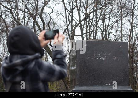 Kiew, Ukraine. November 2023. Eine Frau fotografiert ein leeres Podest im Park, wo sich einst ein Denkmal für den russischen Dichter Alexander Puschkin befand, das kürzlich von Kiewer Stadtverwaltung demontiert wurde. Nach der russischen Invasion verfolgt die Ukraine aktiv die Entrussifizierung, indem sie die Namen, Persönlichkeiten, Symbole und Ideologie Russlands in allen Lebensbereichen aufgibt. Quelle: SOPA Images Limited/Alamy Live News Stockfoto