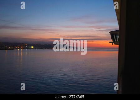 Nach dem Segeln unter der Brücke vom 25. April kommt das P&O-Kreuzfahrtschiff Aurora in Lissabon an und fährt bei Sonnenaufgang über dem Fluss Tejo zum Kreuzfahrtterminal. Stockfoto