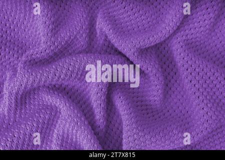 Violette Farbe zerknittert, zerknitterte Strickwolle Textur. Hintergrund von gestricktem Stoff mit Punktmuster. Textilstruktur, Tuchoberfläche, Weben Stockfoto