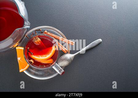 Glühwein Rotwein mit den Gewürzen und Früchten auf einem dunklen Tisch. Traditionelle hot Drink an Weihnachten und Winter Stockfoto