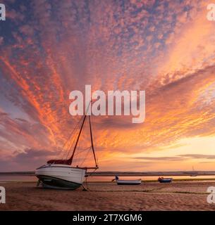 Ein spektakulärer Sonnenaufgang Ende Juni, wenn die Flut in Richtung der kleinen Boote schleicht, die die Flussmündung des Flusses Torridge bei Appledore in North Devon säumen. Stockfoto