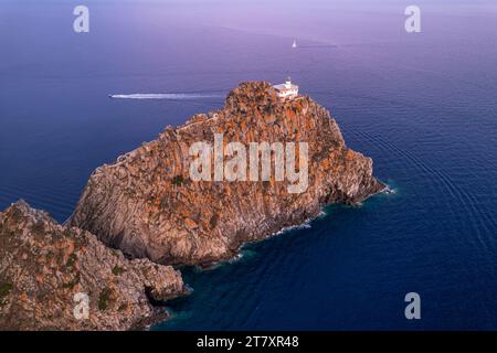 Hoher Blick auf den Leuchtturm von Ponza (Punta della Guardia Leuchtturm) auf der Basaltklippe in der Abenddämmerung, Insel Ponza Stockfoto